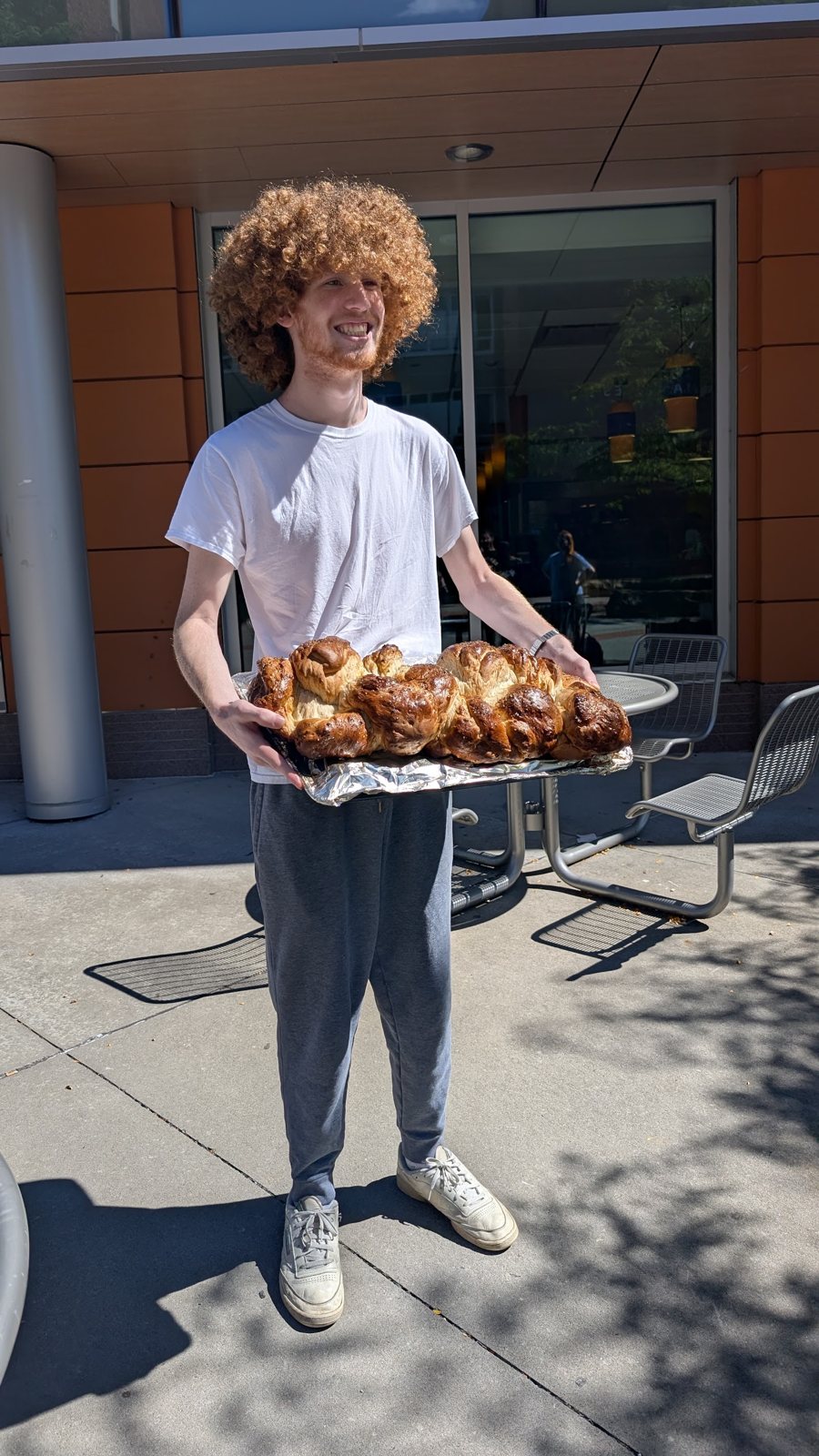 A student carrying a tray of fresh challah