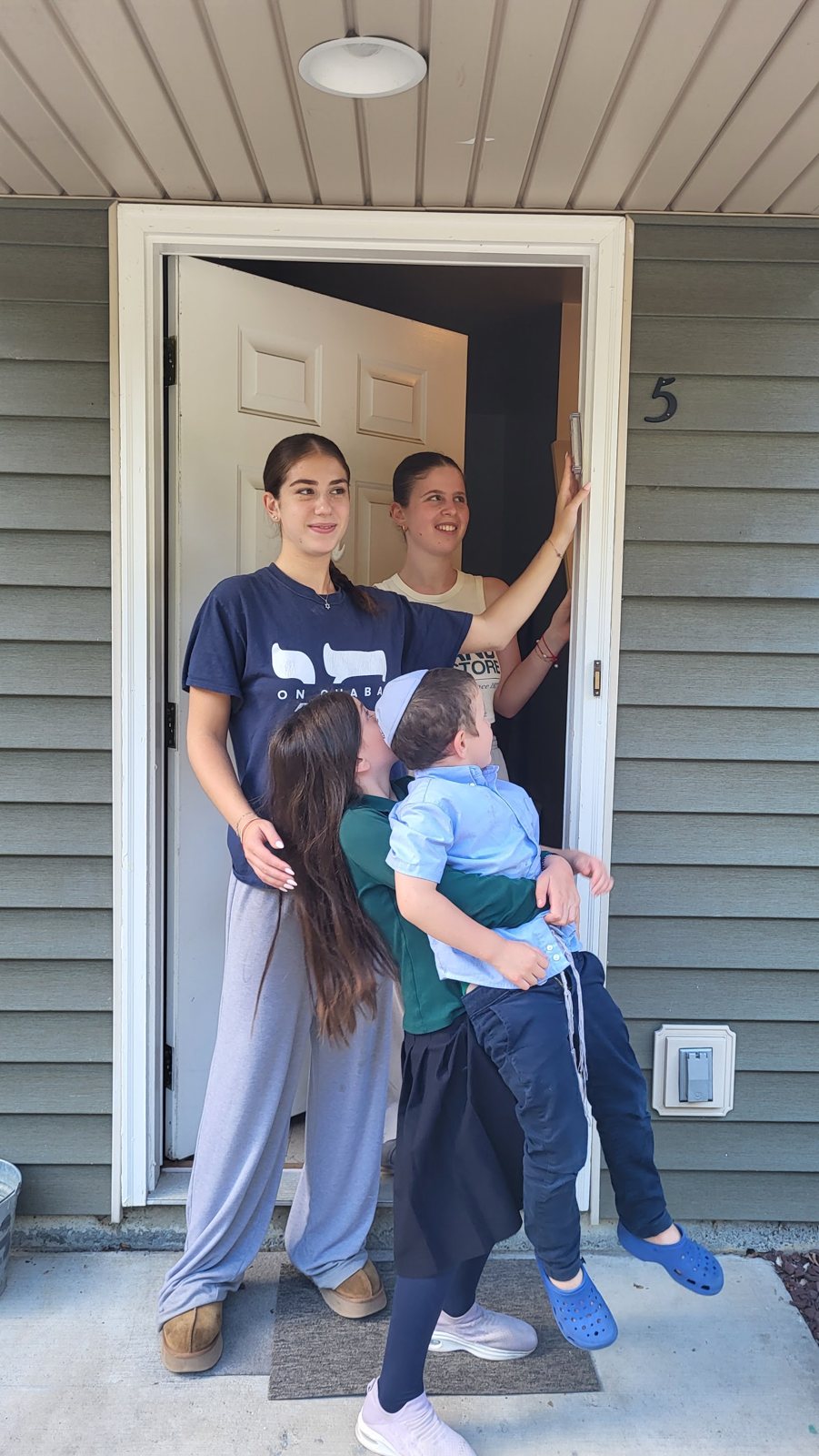 Students putting a mezuzah on a dorm room door