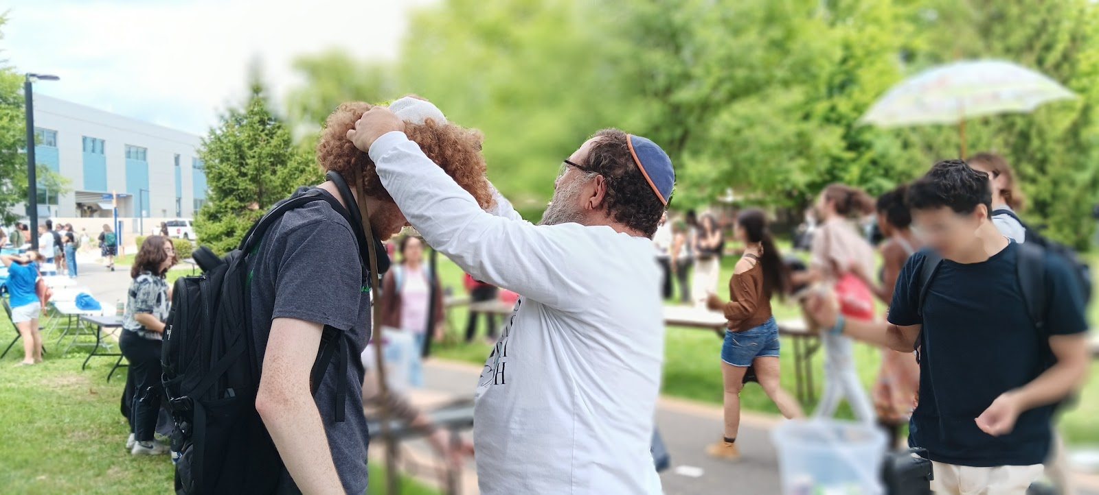 A student putting on tefillin on campus